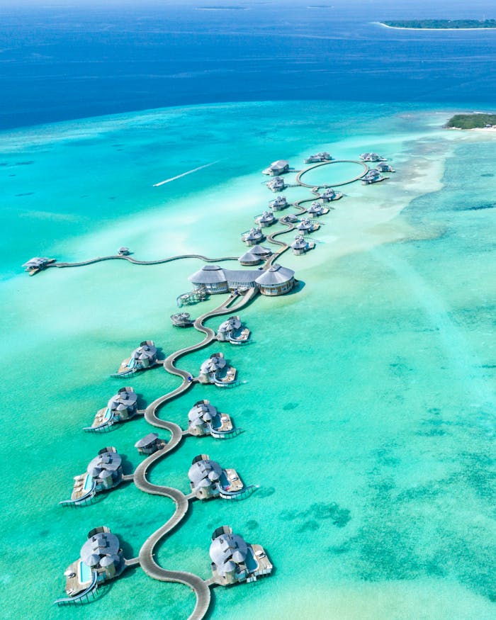 Aerial view of luxury overwater villas at Noonu Atoll, Maldives with turquoise waters.